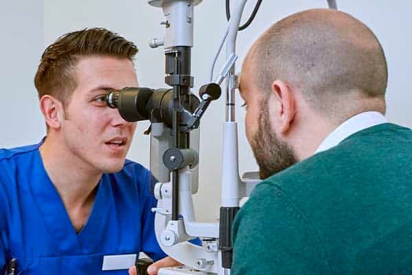 An eye technician at work looking at cataract lens