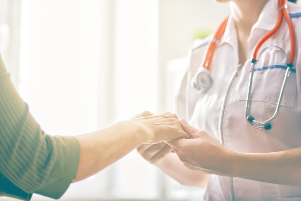 patient and doctor holding hands