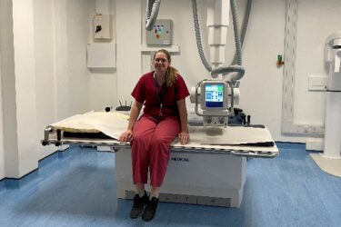 a technician sitting on a medical bed