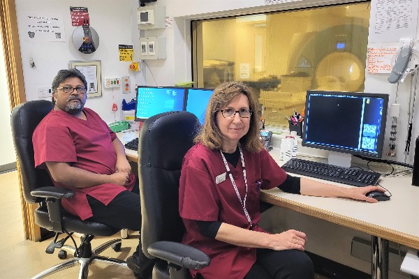 Two radiographers sitting at their desks