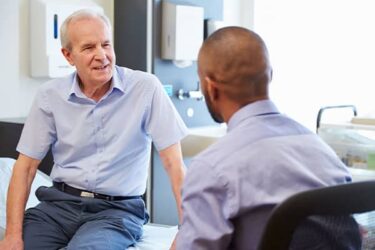 man sat talking and smiling to a consultant