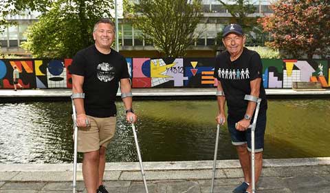 Spencer and his father Dave stand on crutches after their hip replacements in Plymouth