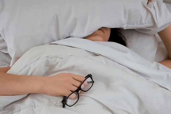 Person sleeping under the covers to avoid snoring partner