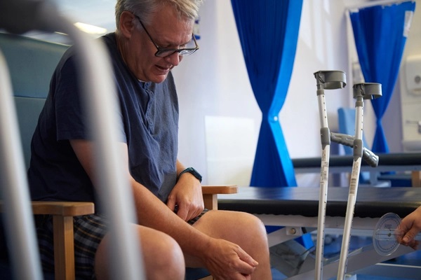 Man sits down in hospital after knee replacement surgery