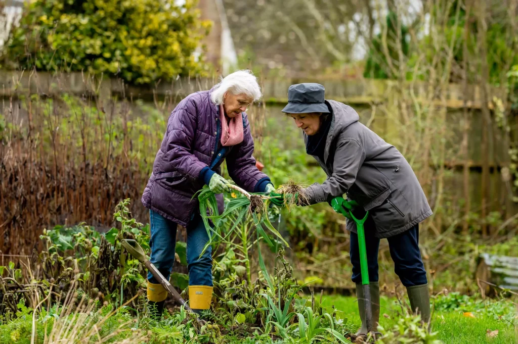 Two women gardening in winter jackets