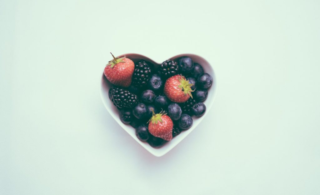 A heart shaped bowl full of berries