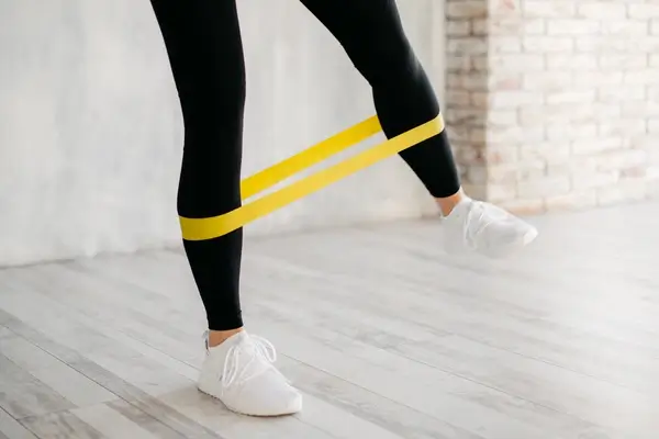 Bottom half of a person's legs using an exercise band