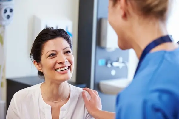 Knee surgeon smiling with patient in a hospital environment