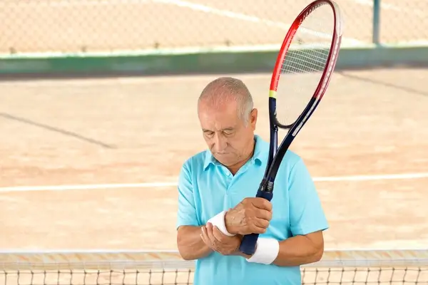 Man suffers from symptoms of carpal tunnel syndrome while playing tennis 