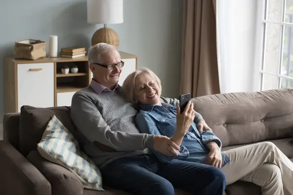 Elderly couple on the sofa looking for a cataract surgeon