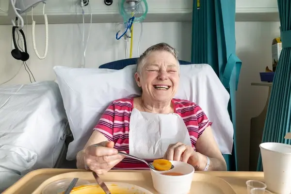 An elderly relative after surgery enjoying breakfast