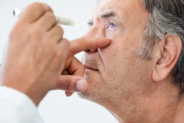 A man having his eye examined for cataracts