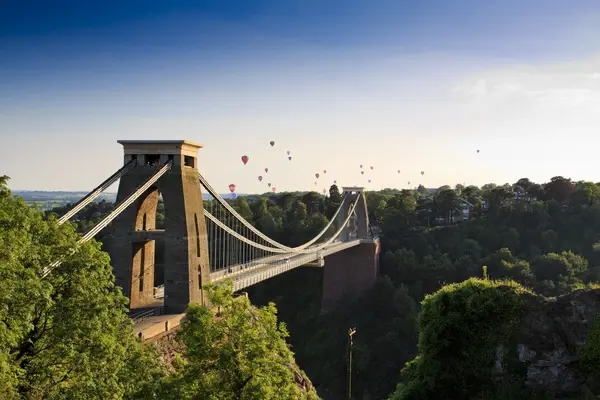 Clifton suspension bridge in Bristol with air balloons floating in the sky