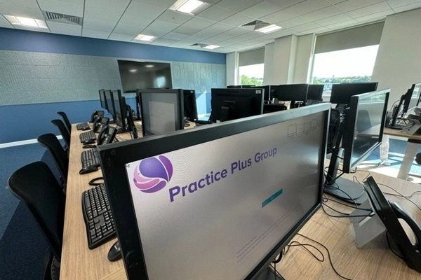 A desk of computers at Practice Plus Group