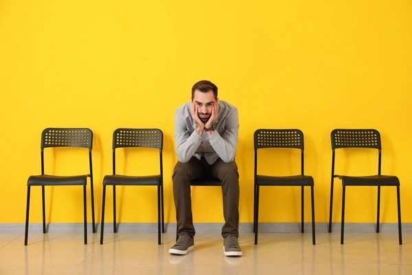 Man waiting on a chair in a waiting room